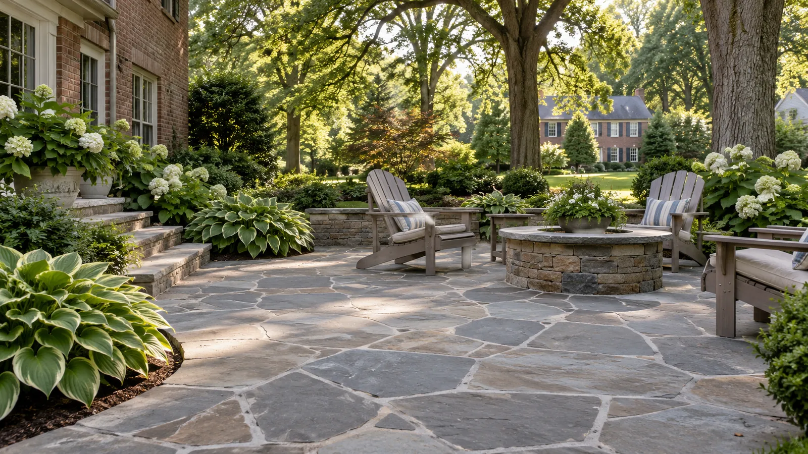 Natural flagstone patio with a round stone fire pit, Adirondack chairs, and hosta beds in a shaded Silver Spring, MD backyard by SiteDoctorMD