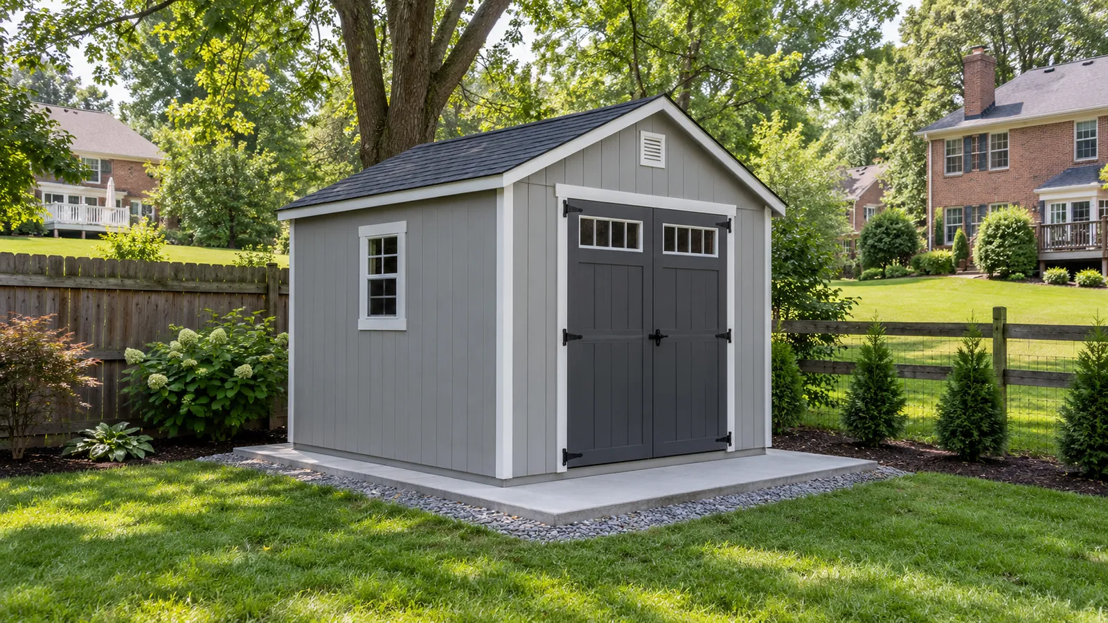 Gray storage shed on a new concrete base with a gravel drip edge in a fenced Maryland backyard, built by SiteDoctorMD